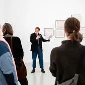 Zwei Kurator*innen erklären Besucher*innen die Ausstellung