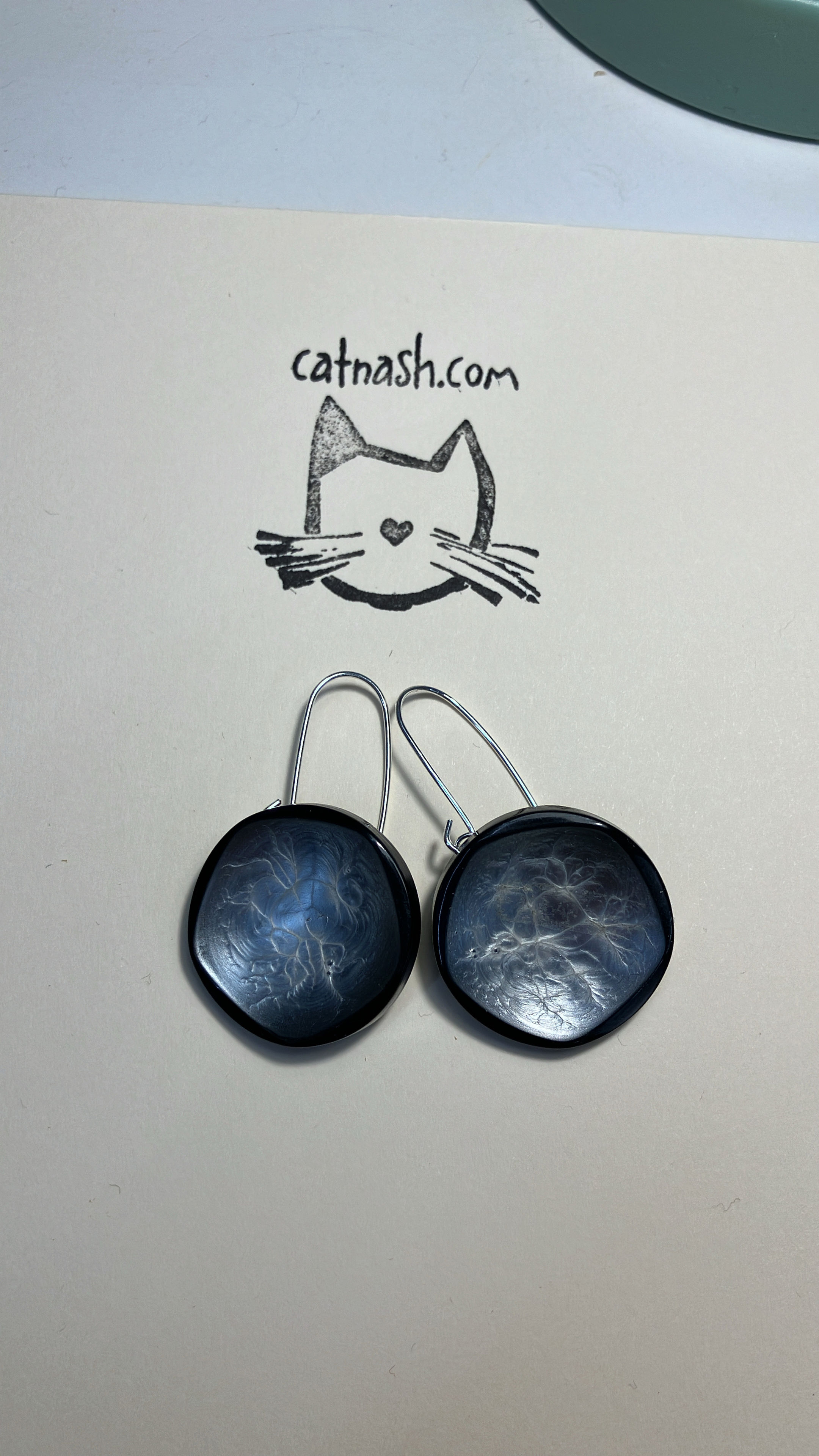Black buttons adorned with a pool of silver