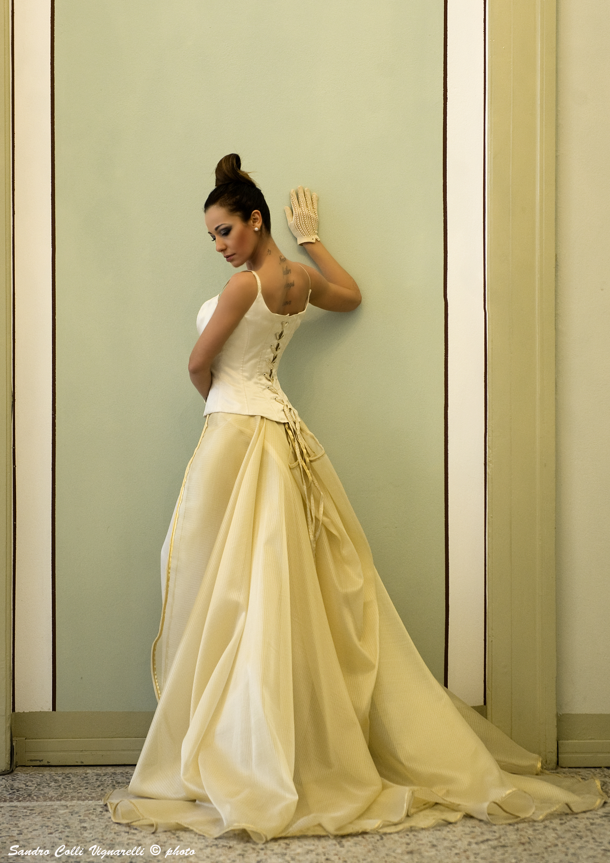 Corsetto steccato oro per l'abito in organza con tubino e coda. Profilo in oro