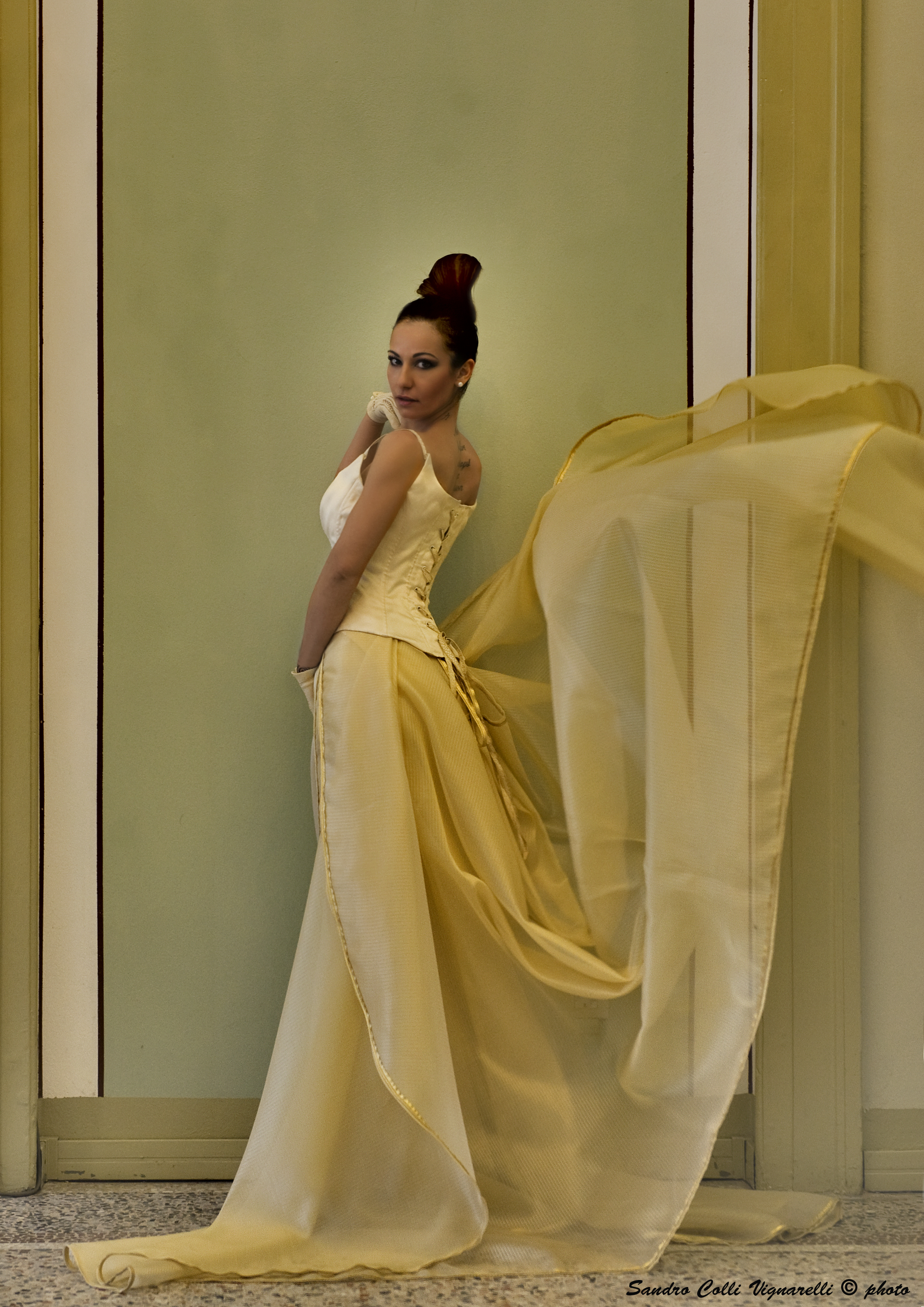 Particolare del corpetto da sposa e coda in oro di organza.