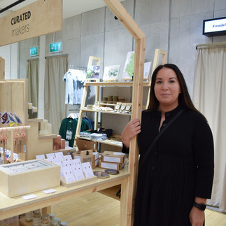 A jewellery maker posing with their products in the Curated Makers Meadowhall store.