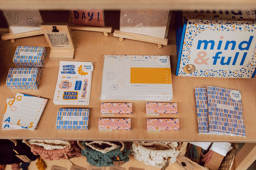 A Curated Makers' display of colourful motivational products such as notepads, stickers and affirmation cards.