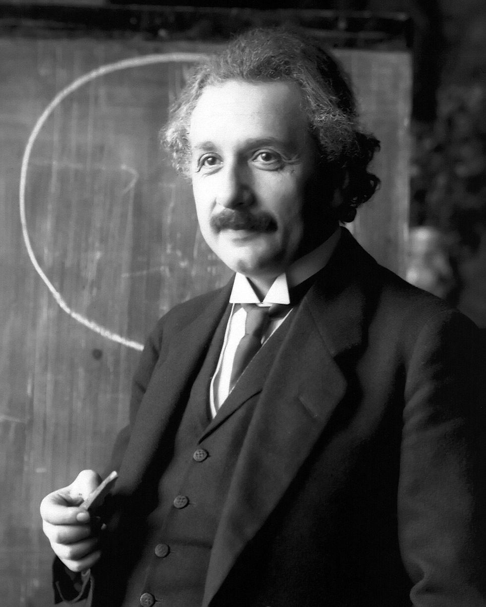 Einstein in a classroom posing for a portrait.