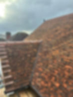Close-up of a completed pitched roof featuring traditional clay tiles and professional valley detailing.