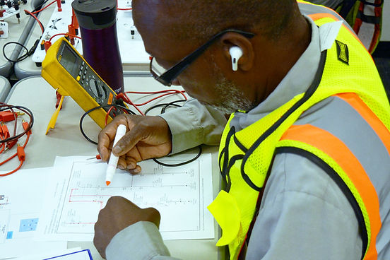 Image of a fleet technician tracing an electrical wiring diagram.