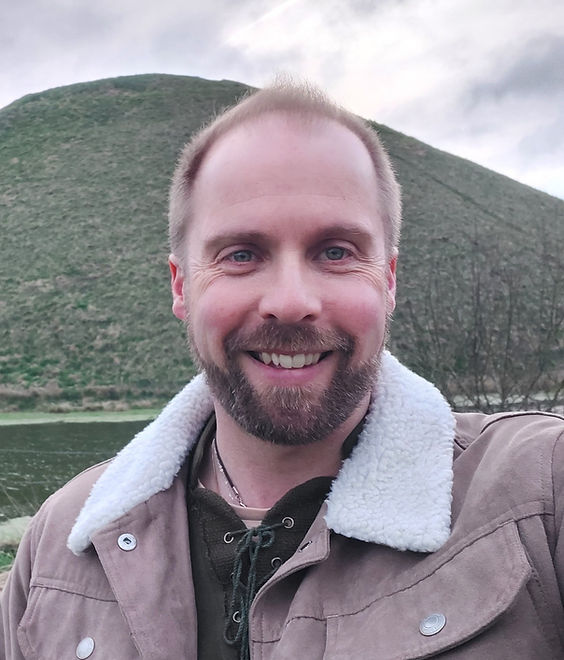 Luke of Luke's Reiki Healing, smiling and very happy with Silbury Hill behind him