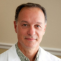 dr damevski in a white lab coat smiling portrait