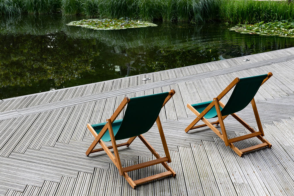 Two deckchairs overlooking a pond