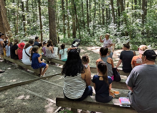 Master Naturalist teaching visitors about bird calls in an outdoor amphitheater