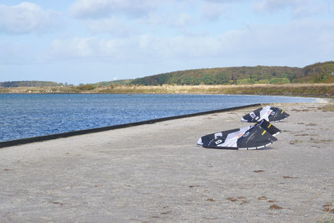 To kites ligger på stranden ved Hestehovedet