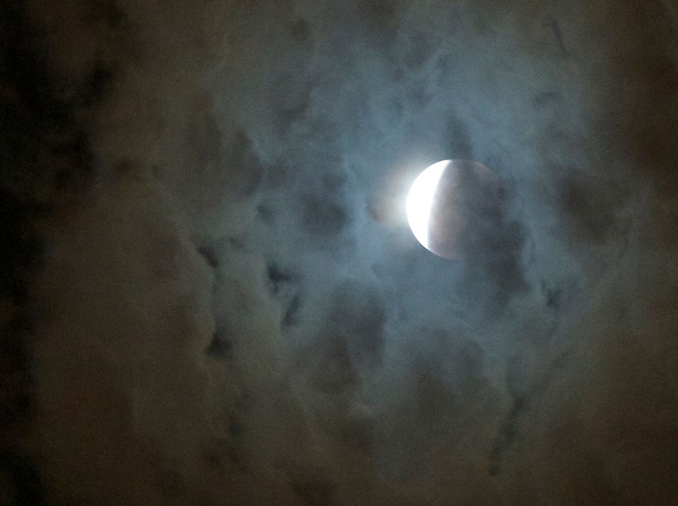 Éclipse lunaire partielle observée dans un ciel nuageux au crépuscule, photo prise à Los Angeles en 2015.
