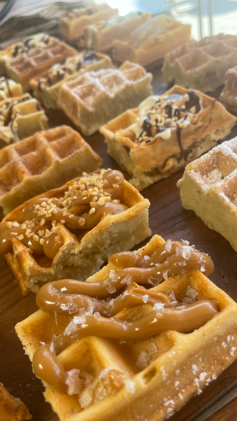 Waffel-Häppchen mit unterschiedlichen Toppings auf einer Holz-Platte
