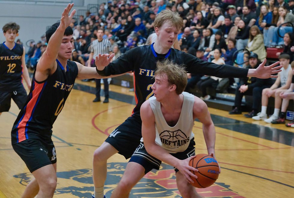 FILCOM's Bryson Echiverri (0) and Sean Oliver (24) defend Metlakatla's Clay Olstad during their A Bracket game on Tuesday, March 24, at the Juneau Lions Club 77th Gold Medal Basketball Tournament in the Juneau-Douglas High School: Yadaa.at Kalé George Houston Gymnasium. (Klas Stolpe / Juneau Independent)