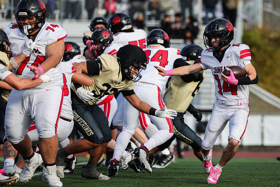 Juneau-Douglas High School: Yadaa.at Kalé senior Krew Ridle (14) avoids South Anchorage sophomore Ezekiel Lealaisalanoa (32) during the Crimson Bears’ 42-12 loss to the Wolverines in the ASAA First National Bowl semifinal football game at South High School, Saturday, Oct. 17, 2026. South advances to play West Anchorage next weekend for the state championship. (Photo courtesy Stephanie Burgoon)