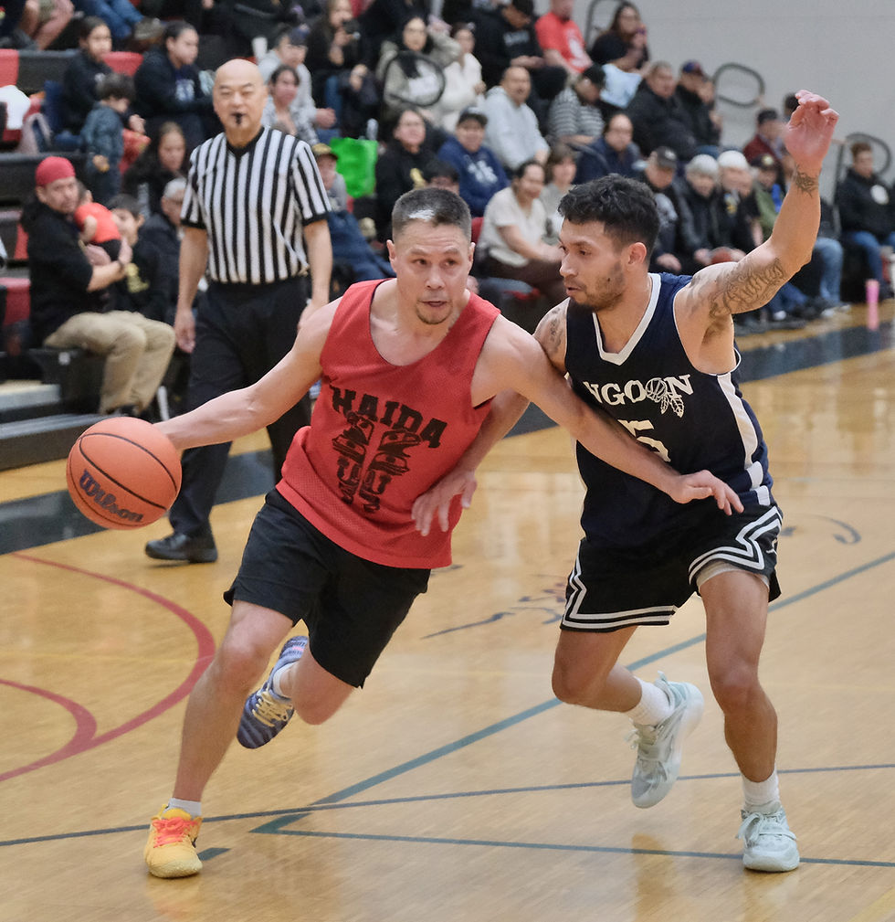 Hydaburg's Vinnie Edenshaw is defended by Angoon's Aquino Brinson during their B bracket elimination game on Wednesday, March 25, at the Juneau Lions Club 77th Gold Medal Basketball Tournament in the Juneau-Douglas High School: Yadaa.at Kalé George Houston Gymnasium. Angoon won 85-77. (Klas Stolpe / Juneau Independent)