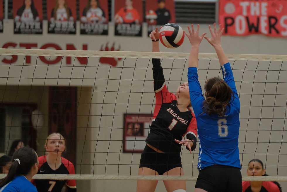 Juneau-Douglas High School: Yadaa.at Kalé senior June Troxel (1) kills a shot past the block of Cordova junior Elizabeth Baenen (6) during the Crimson Bears 3-1 (10-25, 28-26, 25-22, 25-14) win over the Wolverines in the George Houston Gymnasium, Thursday, Oct. 1, 2026. (Klas Stolpe / Juneau Independent)