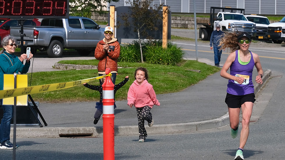 Juneau's Shannon Gress, then age 40, is encouraged by family members as she sprints to the finish of the 2025 Juneau Marathon in a new women's master's record time of 3:03:35. This year's race is Saturday, July 25. (Klas Stolpe / Juneau Independent)