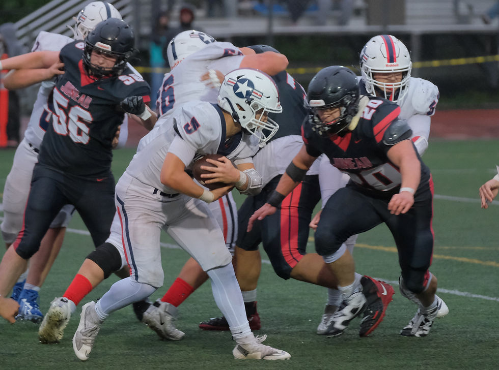 Juneau-Douglas High School: Yadaa.at Kalé senior Jaxin Jim (20) tackles North Pole junior Xavier Barnett (5) during the Crimson Bears’ 52-0 win over the Patriots at Adair-Kennedy Memorial Park on Saturday, Aug. 29, 2026. (Klas Stolpe / Juneau Independent)