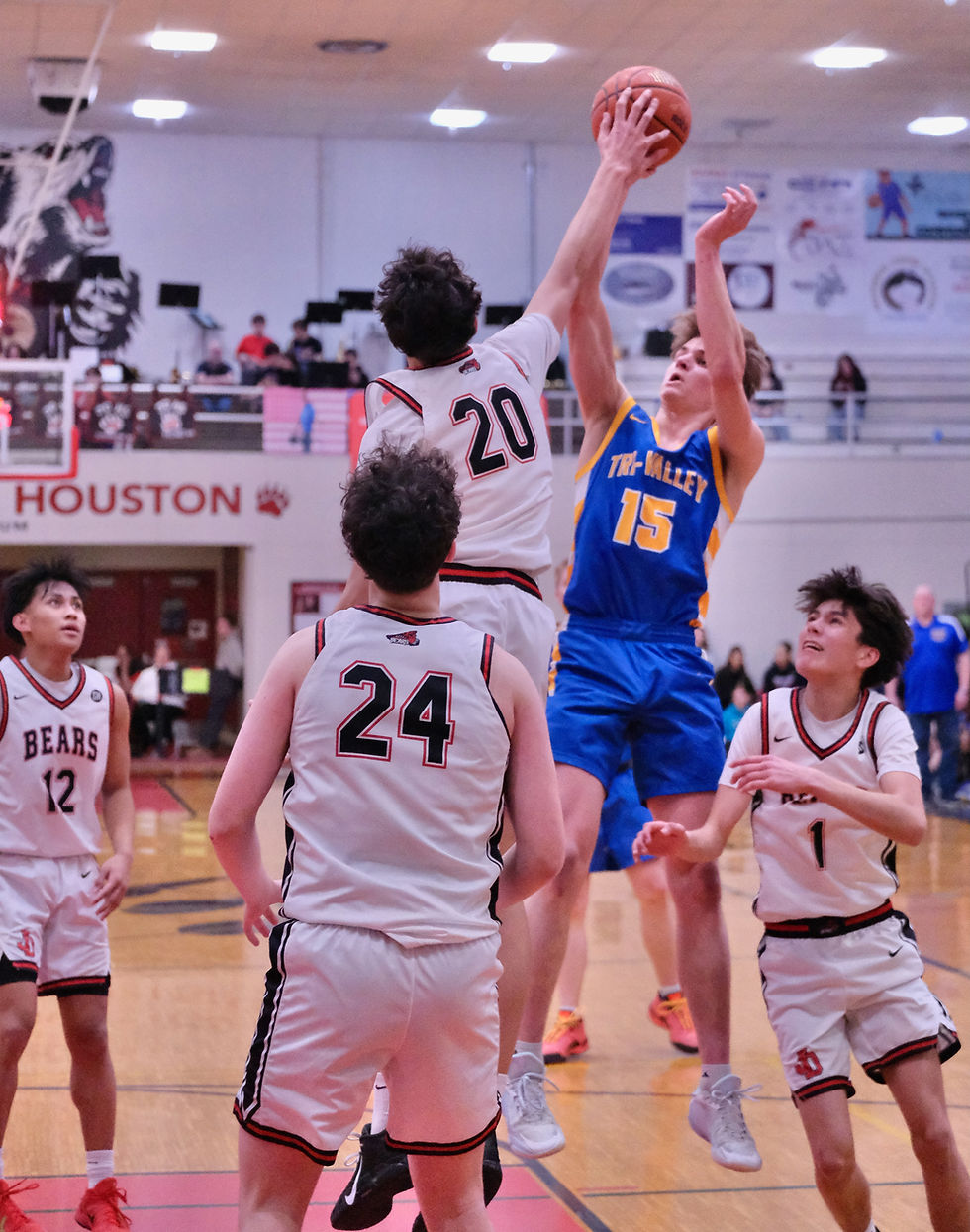 Juneau-Douglas High School: Yadaa.at Kalé senior Elias Dybdahl (20) blocks a shot by Tri-Valley senior Owen Jusczak (15) during the Crimson Bears' 67-45 win over the Warriors on Friday, Feb. 27, 2026, in the George Houston Gymnasium. (Klas Stolpe / Juneau Independent)