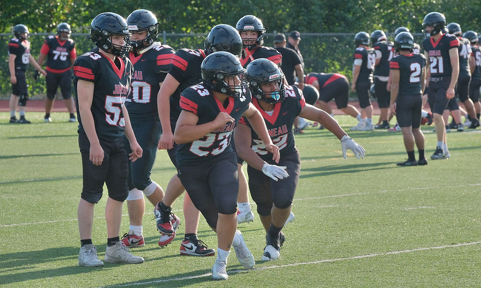 Juneau-Douglas High School: Yadaa.at Kalé junior running backs/line backers Caleb Aube (23) and Jarry Maghinay (22) work a drill during the Crimson Bears scrimmage at Thunder Mountain Middle School's Falcons' Field on Monday, Aug. 10, 2026. (Klas Stolpe / Juneau Independent)