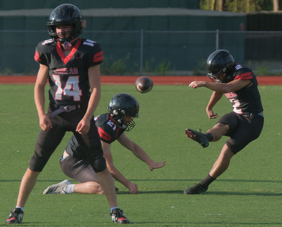 Juneau-Douglas High School: Yadaa.at Kalé senior Krew Ridle (14), junior Andrew Sanders (21) and senior Sonny Mazon (2) work on a field goal drill during the Crimson Bears scrimmage at Thunder Mountain Middle School's Falcons' Field on Monday, Aug. 10, 2026. (Klas Stolpe / Juneau Independent)