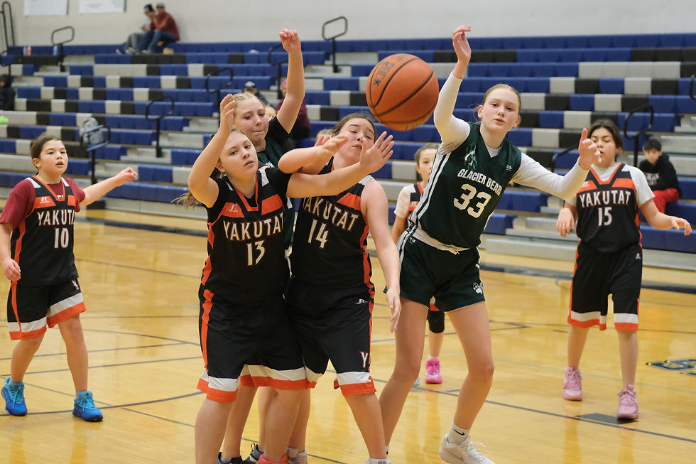 Yakutat's Trinity Ross (13) and Mackenzie Ross (14) and Haines' Maddigan Tersteeg and Ivy Elliott (33) react to a rebound during the TMMS Icebreaker Basketball Tournament. (Klas Stolpe / Juneau Independent)