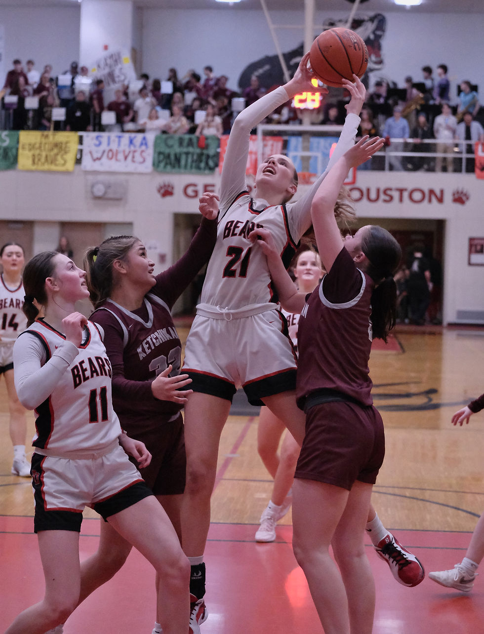 Juneau-Douglas sophomore Athena Warr (21) follows a shot over Kechikan senior Kylie Brendible (32) and freshman Addison Secrest during the Crimson Bears' 55-36 win over the Lady Kings during the 2026 Region V 2A/3A/4A Basketball Tournament on Thursday, March 5, in the Juneau-Douglas High School: Yadaa.at Kalé George Houston Gymnasium. (Klas Stolpe / Juneau Independent)