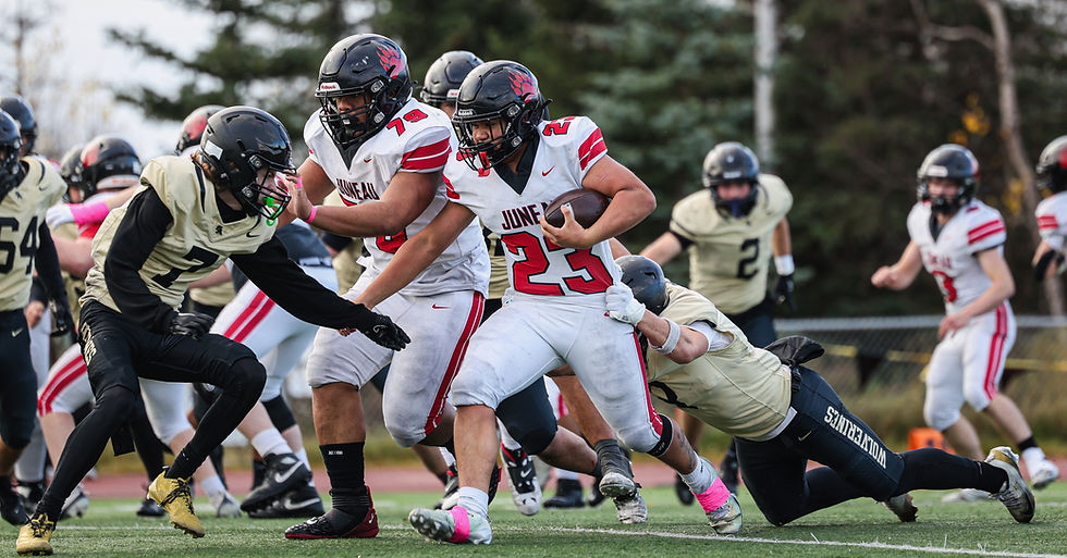 Juneau-Douglas High School: Yadaa.at Kalé junior Caleb Aube (23) runs behind a block from junior Leonidas Taualo-Tasi (79) as South Anchorage junior Austin Duffus (7) and senior Bryson Jackson tackle during the Crimson Bears’ 42-12 loss to the Wolverines in the ASAA First National Bowl semifinal football game at South High School, Saturday, Oct. 17, 2026. South advances to play West Anchorage next weekend for the state championship. (Photo courtesy Stephanie Burgoon)