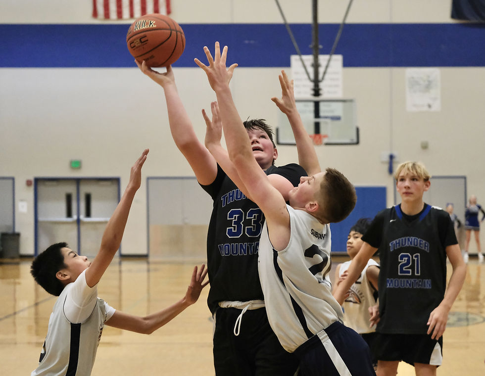 Thunder Mountain Middle School's Micah Polasky (33) shoots over Sitka's Brady Smith (21) during Friday's Icebreaker action in Juneau. (Klas Stolpe / Juneau Independent)