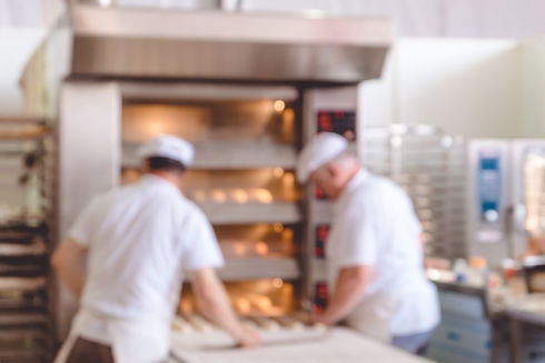 Blurred bakery shop in wholesale store with baking machine, oven, conveyor, production lin