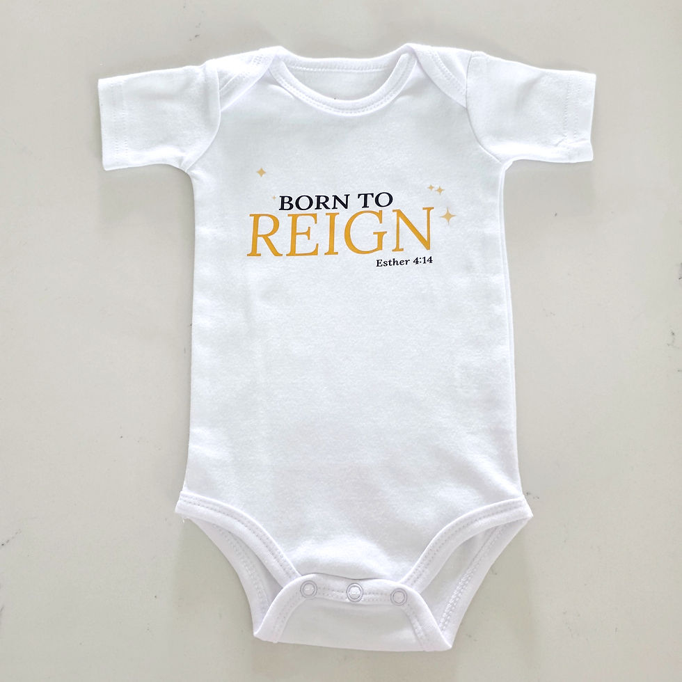 Close-up view of a baby outfit featuring a white romper with angel embroidery and pastel cardigan
