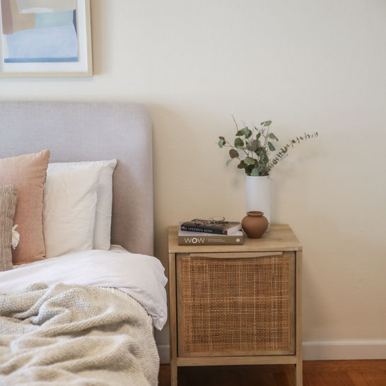 Cozy bedroom with upholstered gray bed and rattan nightstands in Sunnyvale by MiDa interior 