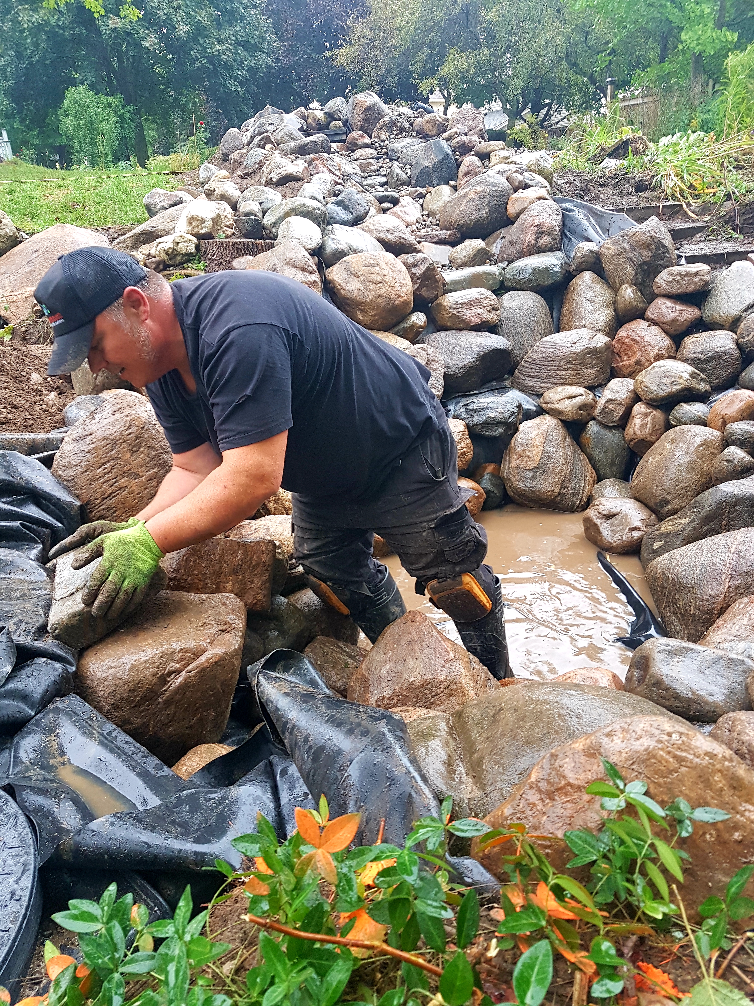 Matt adding rocks to walls of pond