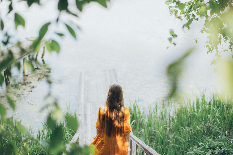 Woman sitting on the shore of a lake