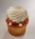 Shortbread bottom below our moist vanilla cake sprinkled with white chocolate then drizzled with a raspberry topping, white chocolate chips, and a dollop of our delicious buttercream.