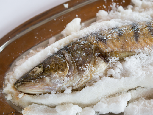 傳統料理「鹽焗魚」，整條鮮魚以厚厚的鹽層覆蓋，經過烘烤後外層結成白色鹽殼，保留魚肉的鮮美與水分，是台灣沿海飲食文化中常見的料理方式之一。