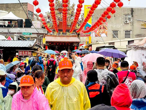 白沙屯媽祖進香回鑾，數百信眾雨中聚集在廟前，紅燈籠高掛映照熱鬧場景，展現台灣信仰文化的熱情與凝聚力。