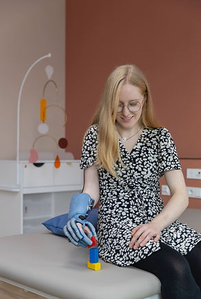 Patientin mit Handprothese vor rosa farbener Wand
