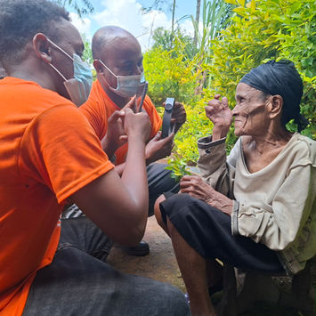 Two men eye-screening an elderly woman