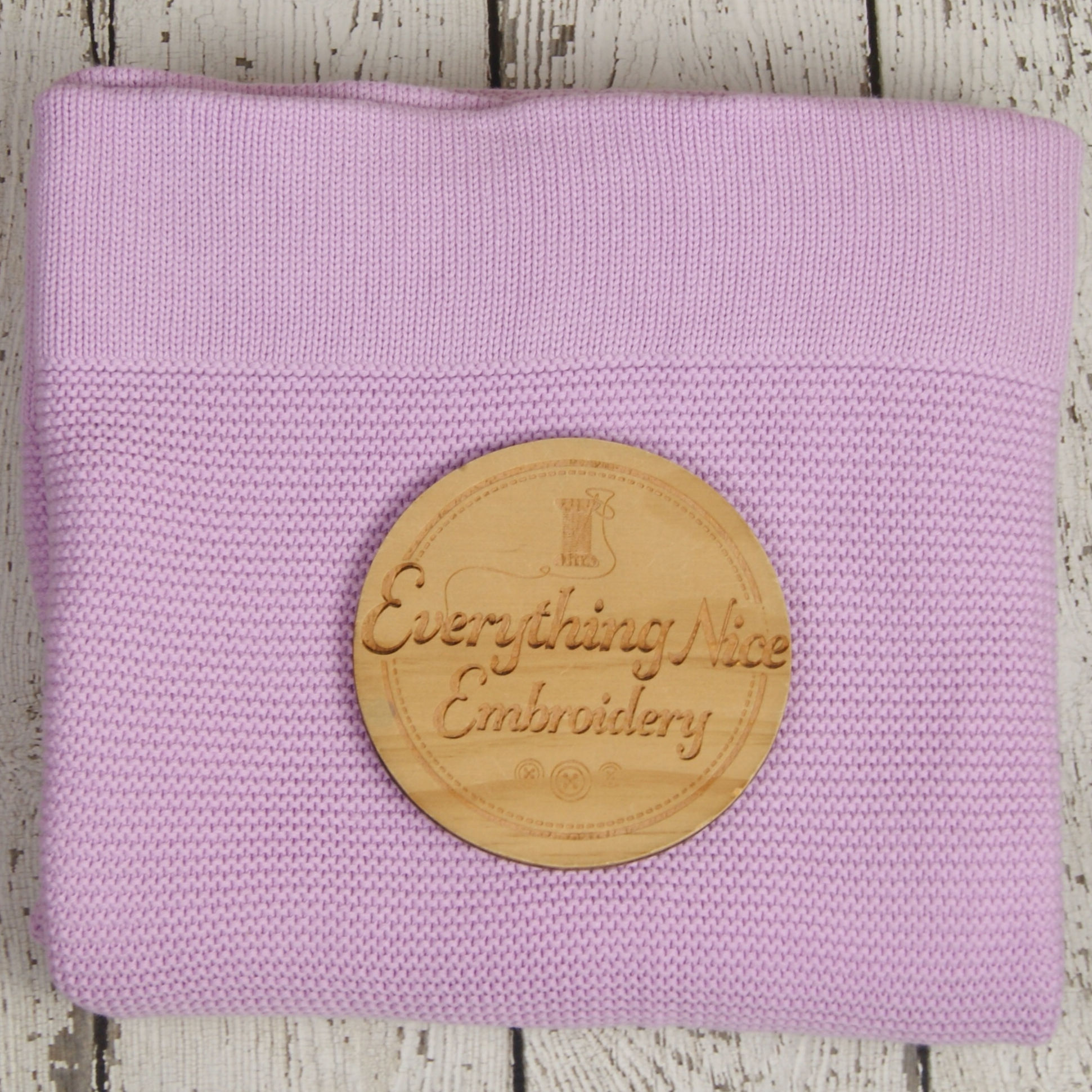 Premium lavender knitted cotton baby blanket displayed on a studio backdrop.