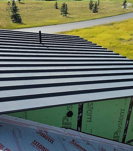 Metal roofing panels stacked outside an Idaho Falls facility, ready for shipment.