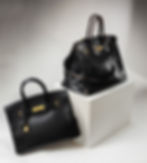 From the auction exhibition, a look at Jane Birkin's original bag up for auction, right, with a current Birkin in black leather, left. (Image courtesy of Sotheby's.)