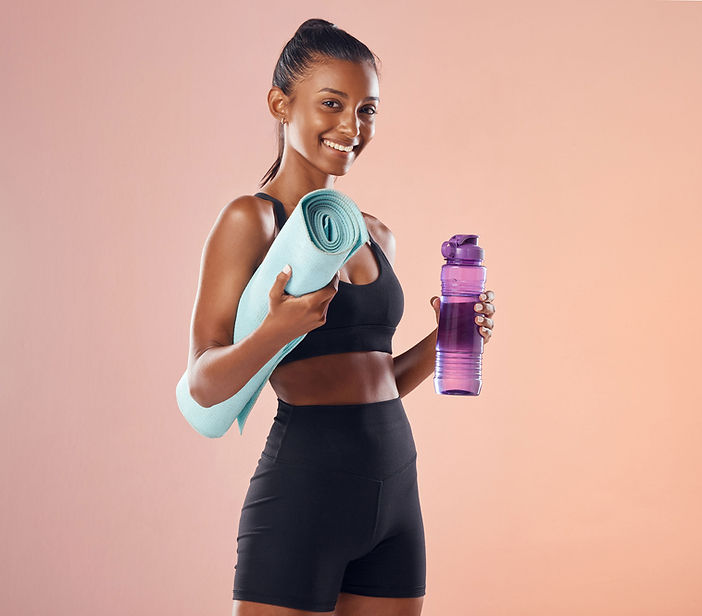 active-woman-getting-ready-routine-fitness-workout-holding-yoga-mat-bottle-while-standing-