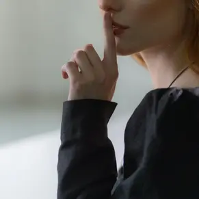 Woman puts fingers to her lips because sex is still a taboo