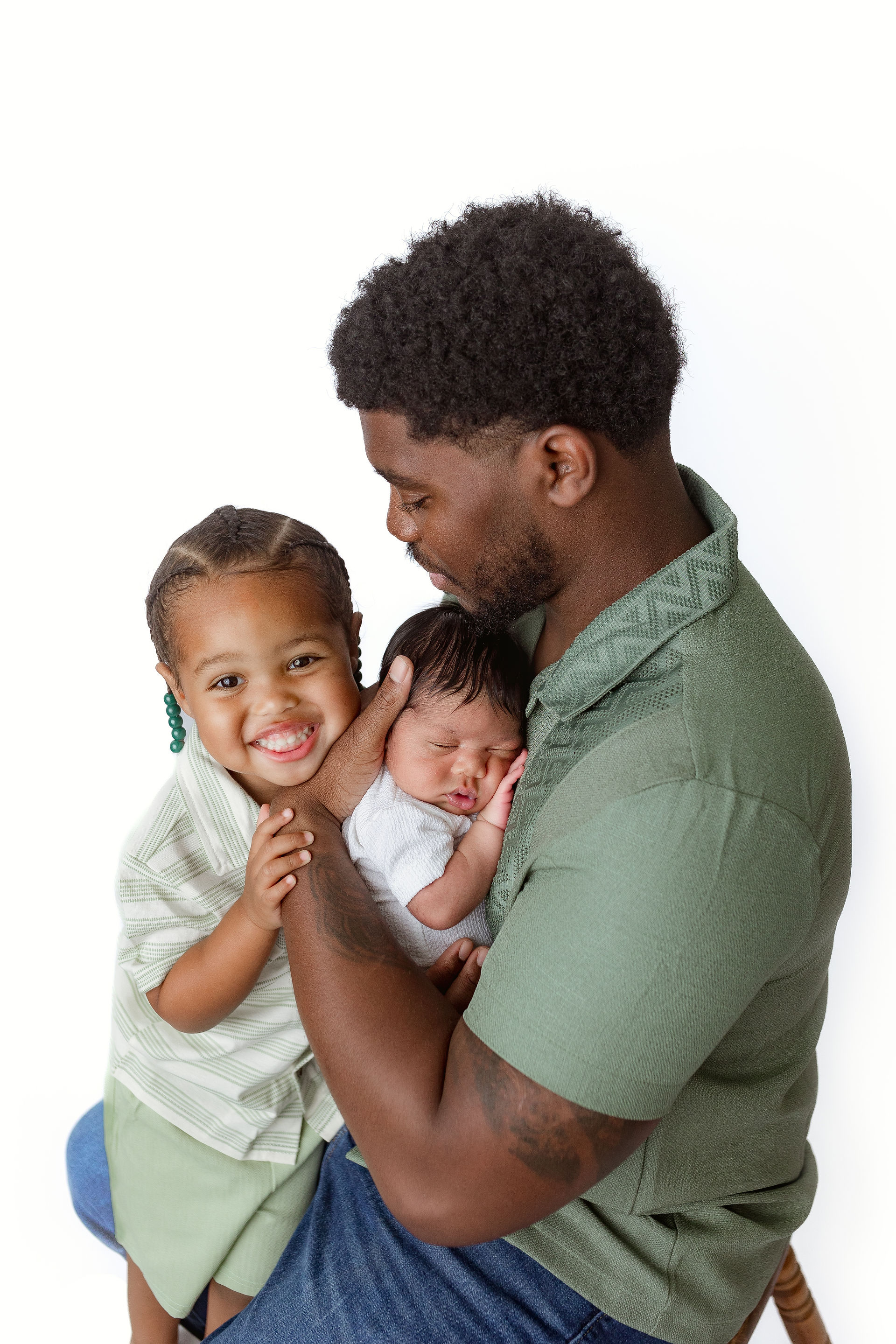 newborn baby posed with dad and big brother