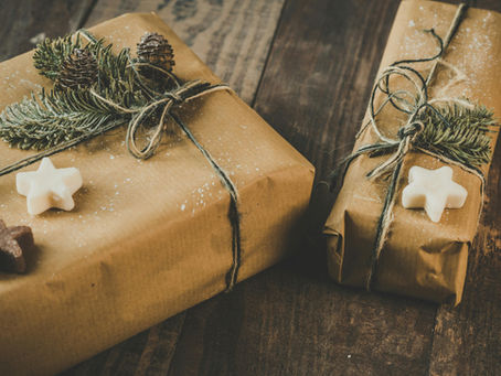 Presents wrapped in brown paper, tied with twine and placed on a wooden floor