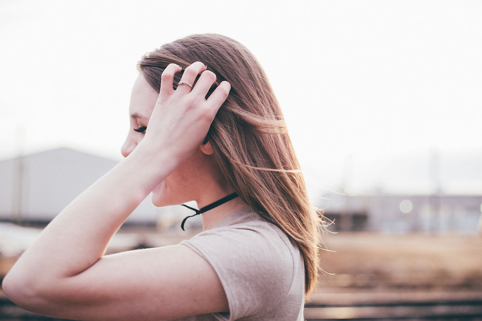 side view of young woman with hand in her hair