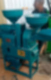 A man stands beside a teal-colored pellet machine on a tiled floor. The machine has two hoppers and a visible logo.