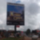 Billboard for "Amalia Meadow Villas" shows a modern house design. Text advertises 5-bedroom homes from Ksh 38.6M. Overcast sky, busy road.