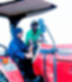 A woman in a blue hijab learns to drive a red Case Farmall tractor with guidance from a man in a green shirt and cap, under a bright sky.